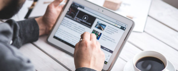 homme cherche l'url de zone telechargement sur sa tablette